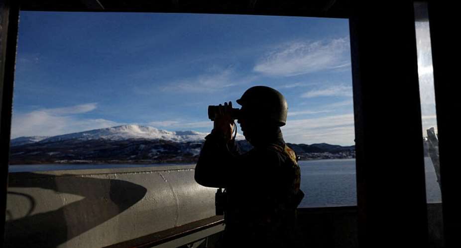 A crew member of the Italian amphibious transport vessel looks through binoculars during the NATO Cold Response 2026 military exercise in the Ofotfjord in Arctic Norway, March 11, 2026 -  Bernadett Szabo, Reuters