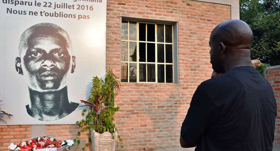 A man stands in front of a plaque in honor of missing Burundian journalist Jean Bigirimana in Bujumbura during a commemoration to mark one year after the journalist's disappearance on July 21, 2017. On August 2, 2019, CPJ joined a call for the U.N. Human Rights Council to extend the mandate of the Burundi Commission of Inquiry. AFPSTRINGER