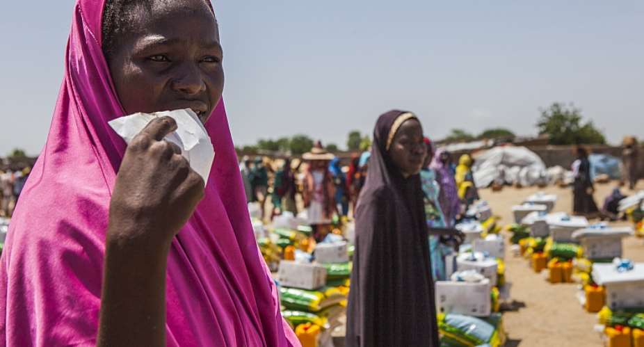Women wait for food distribution to commence at the Government Girls Secondary School IDP camp in Monguno, Nigeria.  - Source: