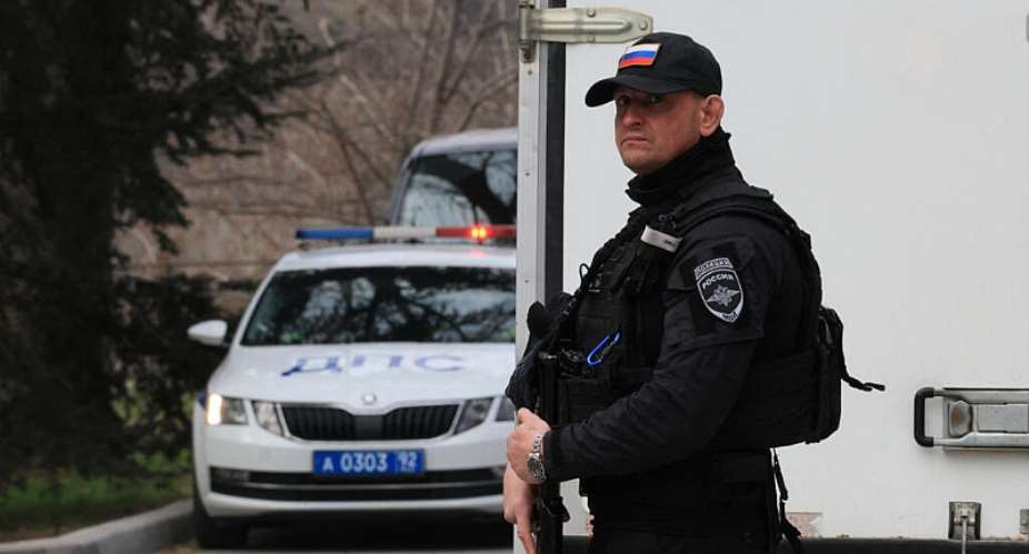 An armed Russian police officer stands guard next to a truck carrying Russian presidential election ballots during its delivery to the local electoral commissions in Sevastopol, Crimea, on March 6, 2024. -  AFP