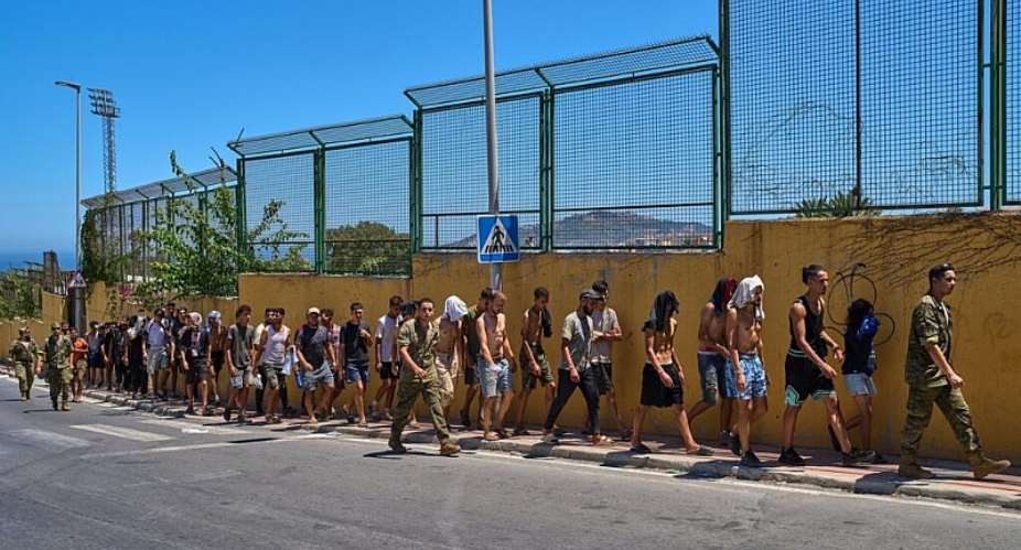 Migrants who crossed into Spain are escorted by Spanish soldiers toward the Spanish-Moroccan border, 2 August. - AP Photo/Bernat Armangue - Bernat Armangue