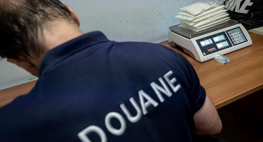 Customs officers inspect envelopes filled with more than 3 kg of cocaine, transported in a luggage of a Dutch passenger, at the Flix Ebou Airport in, French Guiana. - jody amiet / AFP