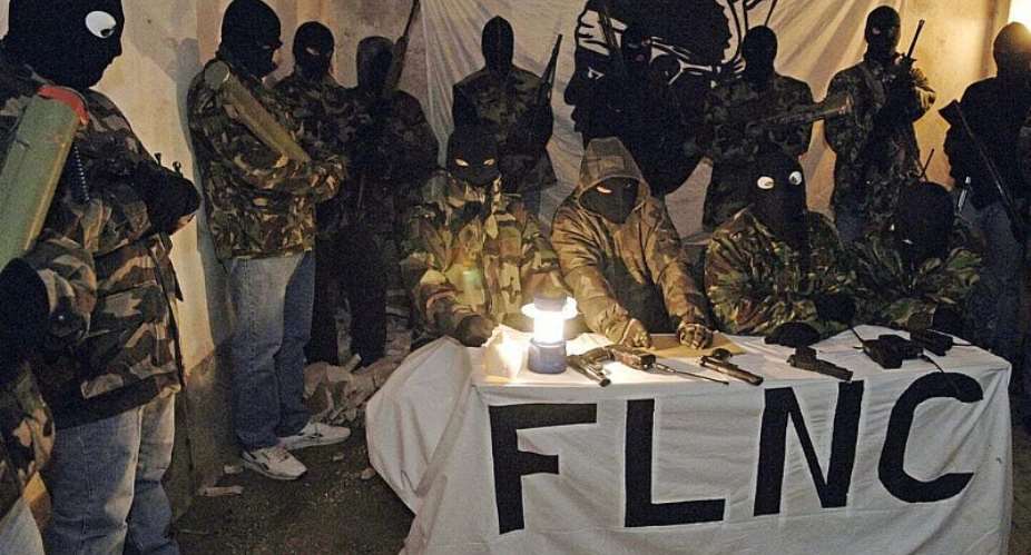 A meeting held in October 2006 between two journalists and spokespeople for the FLNC-UC, surrounded by masked and armed militants. -  AFP