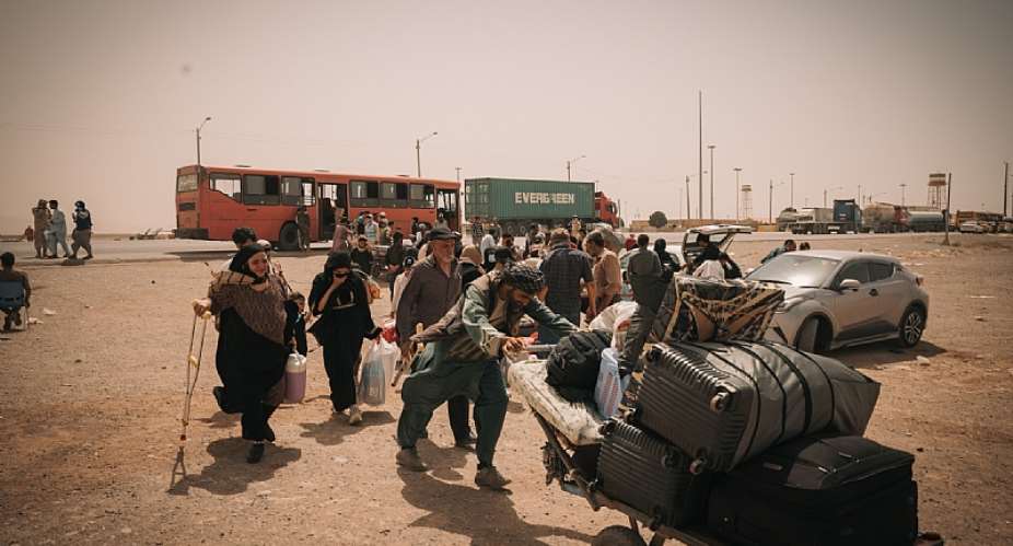 An Afghan family, including a woman with a disability and young children, crosses the border from Iran en route to IOM’s reception center in Islam Qala. Photo: IOM 2025/Mohammad Osman Azizi