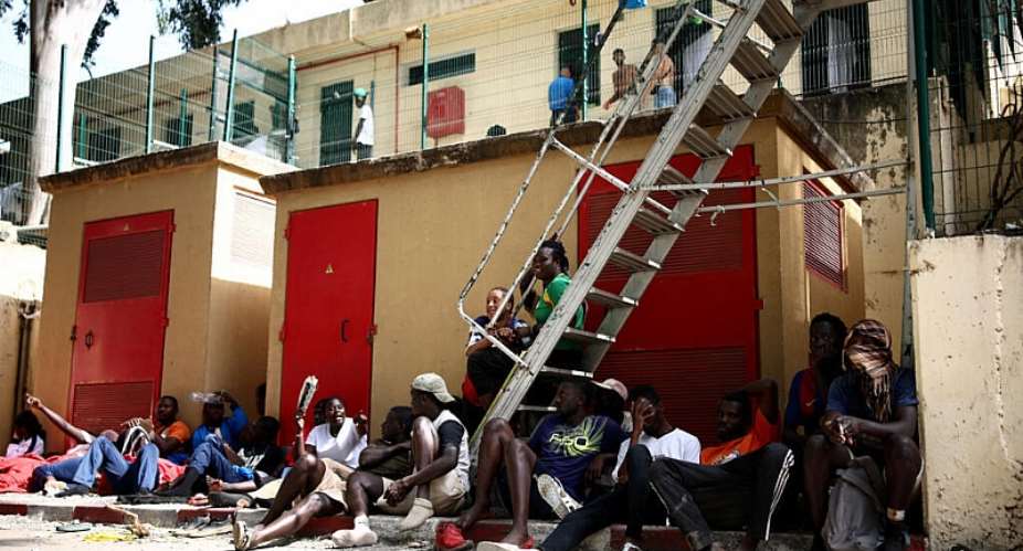 Migrants sit outside the CETI short-stay migrant centre in the Spanish North African enclave of Ceuta. -  Henry Nicholls / AFP/File