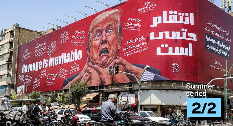 A woman walks past a large billboard pledging revenge against US President Donald Trump along Jomhouri Street in central Tehran on July 27, 2026. -  AFP