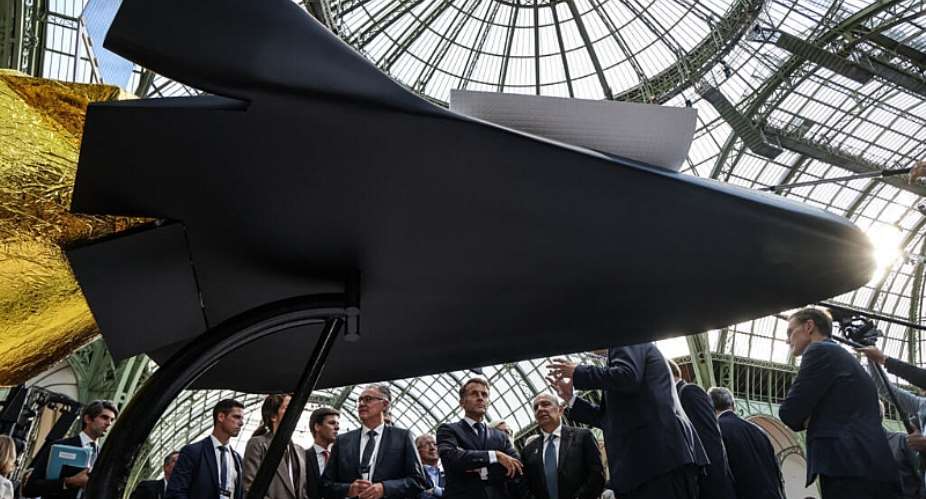 Frances President Emmanuel Macron (C) speak with Dassault Aviation CEO Eric Trappier (C-R) as they look at a model of a Dassault Vortex space vehicle project during the International Space Summit at the Grand Palais in Paris on September 9, 2026. -  Ludovic Marin, AFP