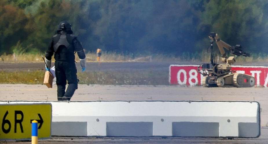 A police officer in protective clothing walks next to an explosive-disarming robot at Leipzig/Halle Airport in Schkeuditz, Germany, August 5, 2026. -  Axel Schmidt, Reuters