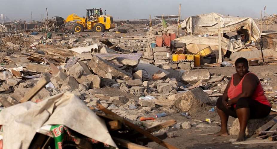 A woman sits at a site in James Town, Accra, demolished in May 2020 to make way for a new fishing port complex.  - Source: Photo by Nipah DennisAFP via Getty Images