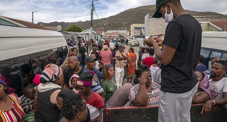 Residents of Masiphumelele informal settlement in Cape Town gather to collect food parcels provided by One South Africa Movement representative.  - Source: EFE-EPANic Bothma