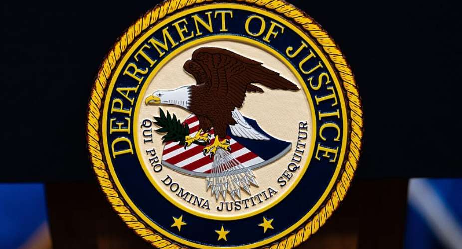 The US Department of Justice logo is seen on a podium before a news conference on May 4, 2026, in Washington. -  Julia Demaree Nikhinson, AP