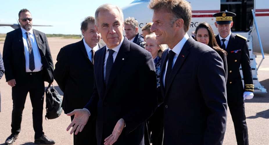 President Macron, right, greets Prime Minister Mark Carney as he arrives in Saint-Pierre on the French territory of Saint-Pierre-et-Miquelon. - Adrian Wyld/The Canadian Press v - Adrian Wyld
