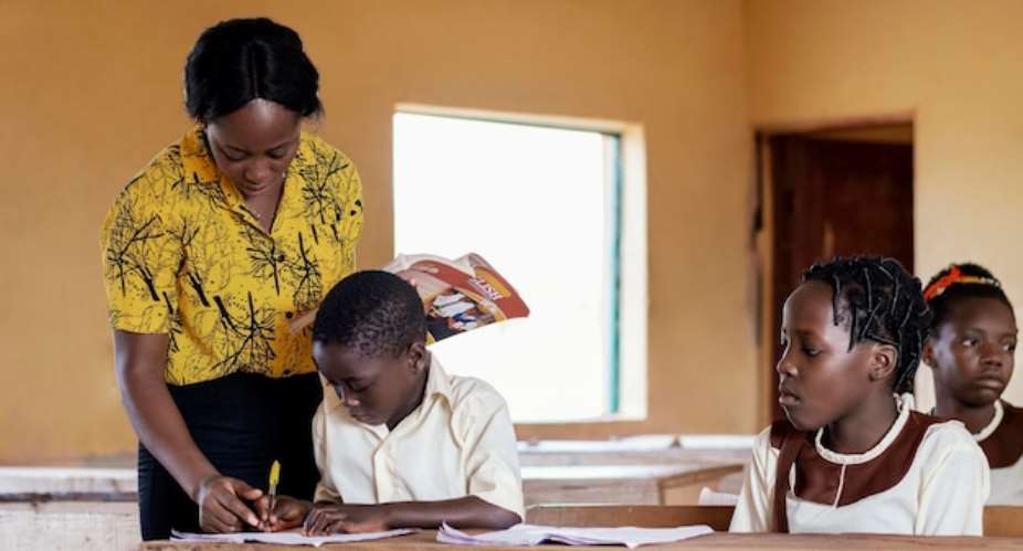 A female teacher helping a pupil in a classroom
