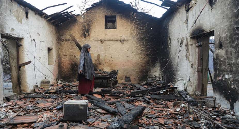 A woman inspects her damaged house after it was burned down in a forest fire in Bordj Thar, a town and commune in Algerias northeastern Jijel Province, 27 August. - AFP - -