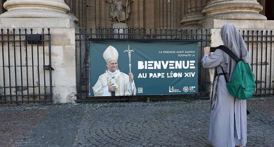 A nun takes a picture of a banner welcoming Pope Leo to France, outside Saint Sulpice church in Paris on 23 September 2026. -  REUTERS - Abdul Saboor