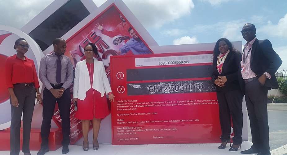 Vodafone executive managers standing by a dummy scratch card.