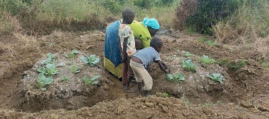 A mother cultivates a permagarden with her children Photo Credit The Permagardens Foundation