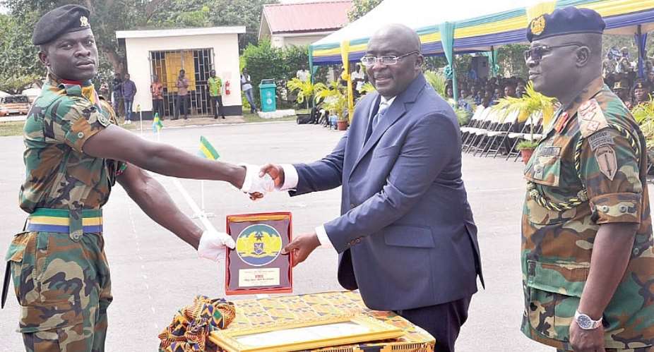 Vice-President Dr Bawumia presenting a plaque to Lance Bombadier Samuel Kojo Afful for his outstanding performance. With them is Maj. Gen. William Ayamdo right, Chief of the Army Staff