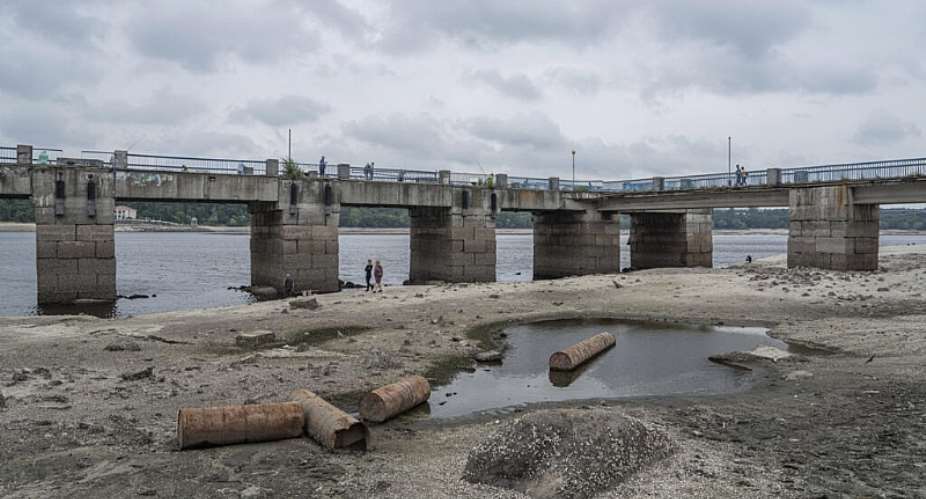 People walk on a central beach as a water in Dnipro river dropped for more than 4 meters after the explosion of the Kakhovka dam in Zaporizhzhia, Ukraine, July 9, 2023. -  Evgeniy Maloletka, AP