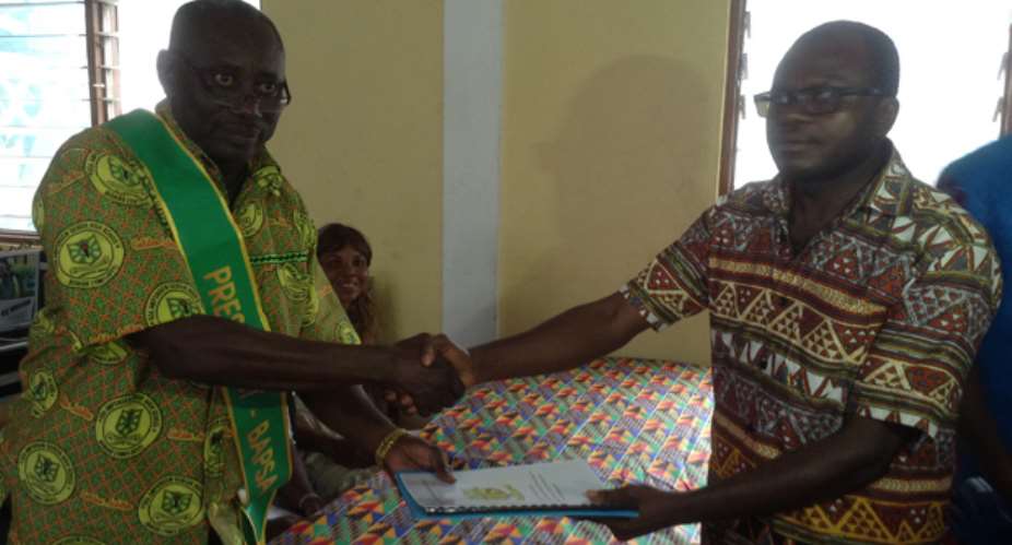 Dr. Owusu Ansah (R) handing over a copy of BAPSA constitution to Mr. Asamoah