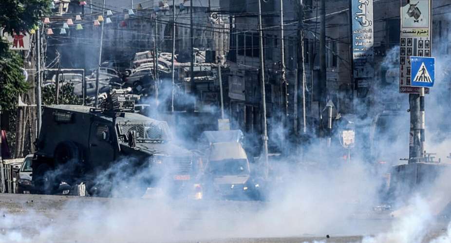 Israeli forces block a street and fire tear gas during an Israeli raid between the Kafr Aqab neighbourhood and the Qalandia refugee camp, south of the West Bank city of Ramallah, on August 25, 2026. -  Zain Jaafar, AFP