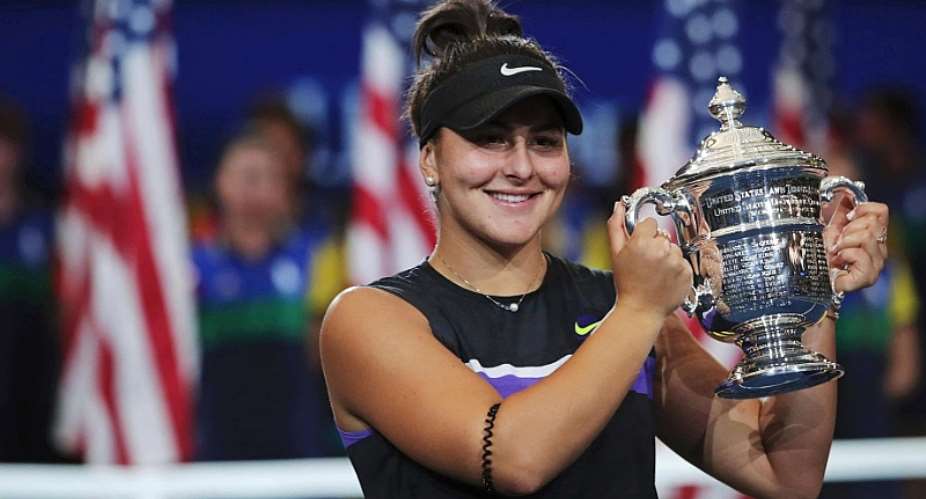 Bianca Andreescu poses with the winning trophy after her two-set victory over Serena Williams.