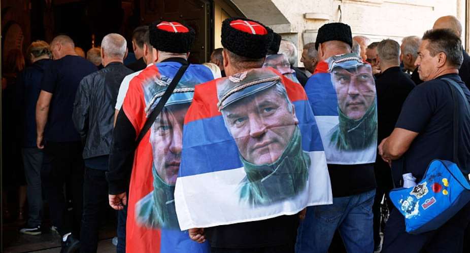 People line up to pay their respects to the former Bosnian Serb army commander Ratko Mladic, seen on the flags, who died last week while serving a life sentence for genocide and other atrocities during the war in Bosnia, at the St. Luka Church, in Belgrade, Serbia, Monday, Sept. 7, 2026. -  Marko Drobnjakovic / AP
