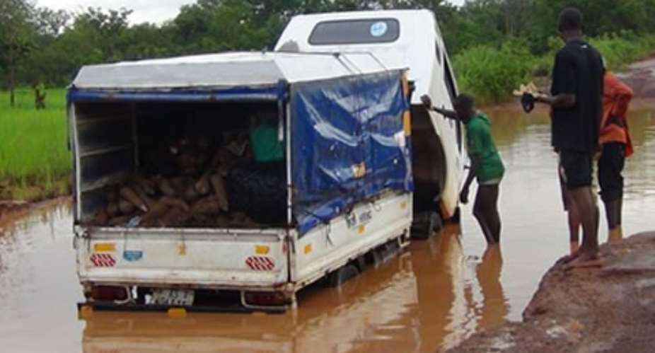 Tubers of yam in a cargo car stuck at one point of the road. Looking on are some frustrated traders and drivers of the vehicle
