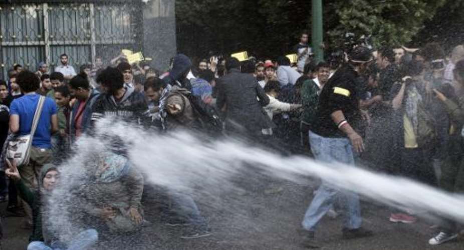 Egyptian policemen use a water canon to disperse protesters during a demonstration organized by the group No Military Trials for Civilians in front of the Shura council in downtown Cairo on November 26, 2013.  By Khaled Desouki AFP