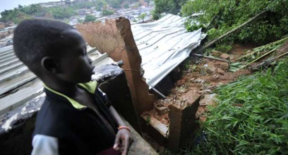 A child looks at a house destroyed by a landslide in the poor neighborhood of Mossikro, western Abidjan on June 5, 2014.  By Sia Kambou AFPFile