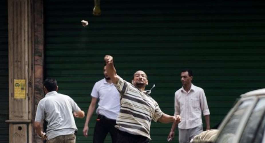 A supporter of ousted president Mohamed Morsi throws stones, in Cairo, on August 13, 2013.  By Gianluigi Guercia AFP