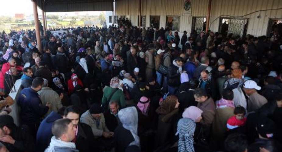 Palestinians await permission to enter Egypt as they gather inside the Rafah border crossing between Egypt and southern Gaza Strip on December 21, 2014.  By Said Khatib AFP