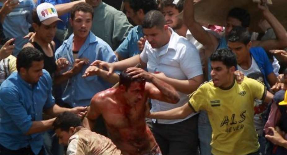 Egyptian protesters beat a man who they accused of attacking them in the Abbassiya district in Cairo.  By  (AFP)