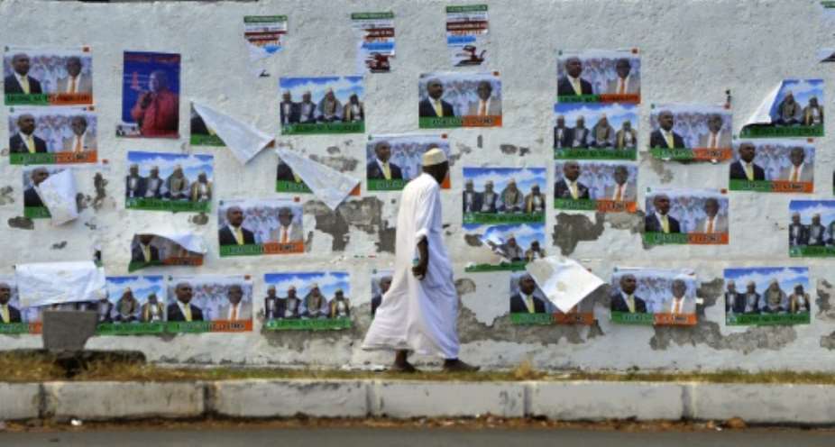 A Comoran man walks past campaign posters on his way to vote during the presidential elections on December 26, 2010 in the capital Moroni.  By Simon Maina AFPFile