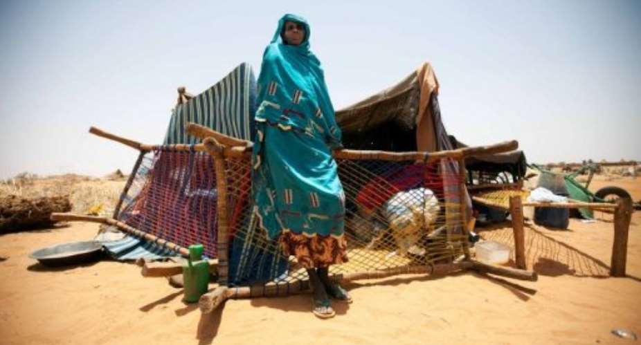 A woman in front of her shelter in the Zam Zam camp for Internally Displaced Persons in North Darfur on May 22, 2013.  By Albert Gonzalez Farran (UNAMID/AFP)