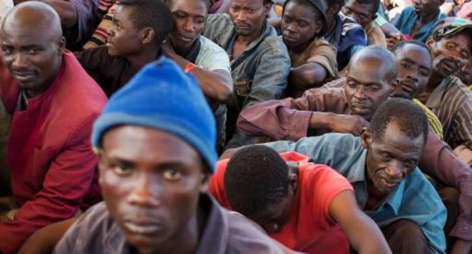 Burundian refugees wait for food at the Lake Tanganyika Stadium in Kigoma, western Tanzania, on May 20, 2015.  By Daniel Hayduk AFP