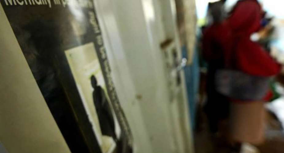 Psychiatric patients stand next to an advocacy poster in one of Nairobis shantytowns, Kangemi on April 11, 2007.  By Tony Karumba (AFP/File)