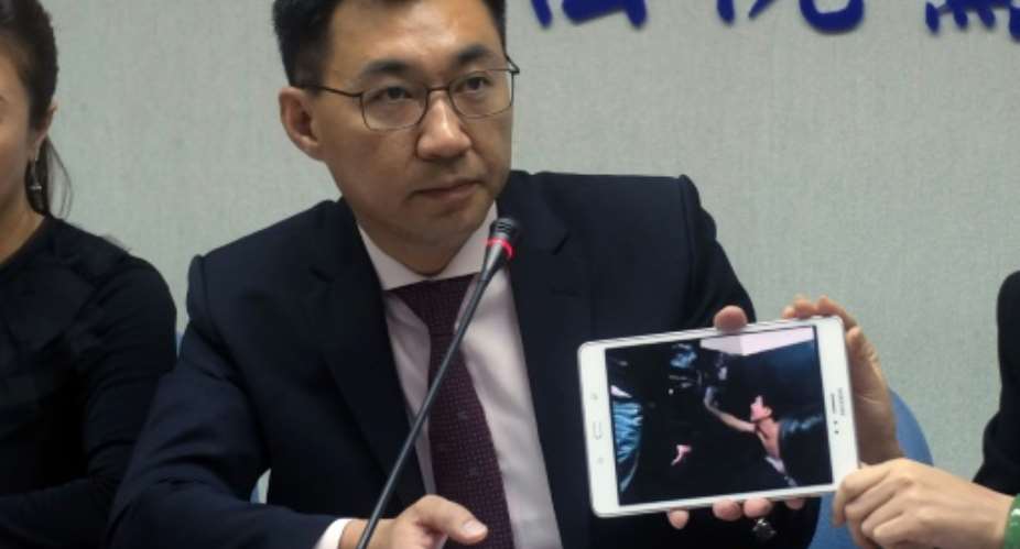 Johnny Chiang, a legislator from the Kuomintang KMT party, displays a video clip showing Taiwanese detented at a police station in Kenya, during a press conference at Parliament in Taipei on April 12, 2016.  By Sam Yeh AFPFile
