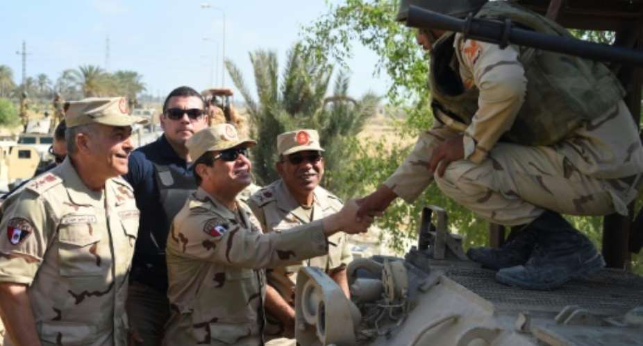File picture released by the Egyptian Presidency shows President Abdel Fattah al-Sisi C shaking hands with a member of the security forces during a visit to the Sinai Peninsula.  By Mohamed Abdelmoaty EGYPTIAN PRESIDENCYAFPFile
