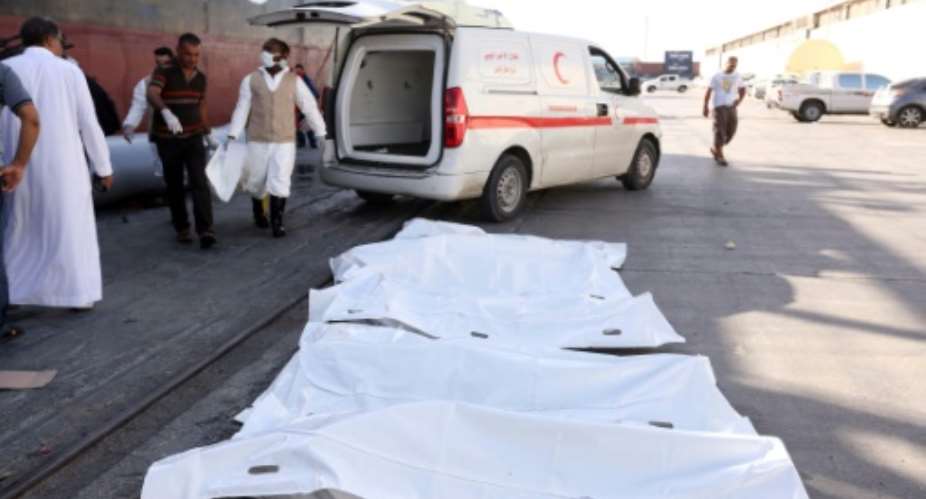 Members of the Libyan Red Crescent collect the bodies of illegal migrants after a Libyan oil tanker rescued a group of migrants off the coast of the Libyan capital Tripoli on September 18, 2015 at Tripoli's port.  By Mahmud Turkia AFPFile