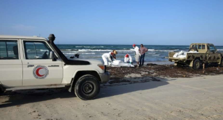 Libyan Red Crescent personnel retrieve the body of a migrant that washed up on a Libyan beach on June 3, 2016.  By  AFPFile