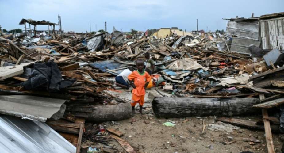 A boy in the Ivorian team jersey at his demolished home in Koumassi Campement.  By Sia KAMBOU (AFP)