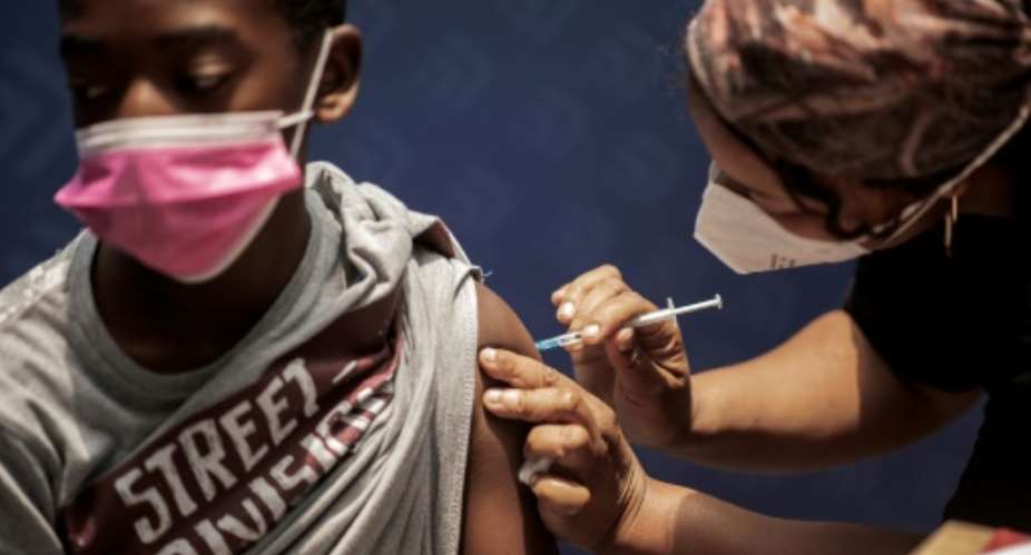 A boy receives a dose of the PfizerBioNTech vaccine against COVID-19 at Discovery vaccination site in Sandton, Johannesburg.  By LUCA SOLA AFPFile