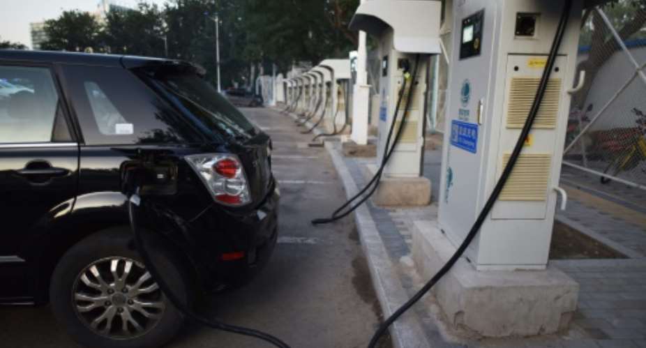 A BYD electric car charges at a charging station in Beijing on September 11, 2017.  By GREG BAKER AFP