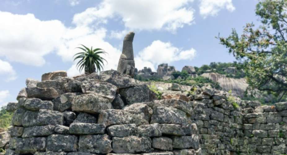 A carved bird in standstone temporarily left an on-site museum to take up its rightful place in the Great Zimbabwe ruins, symbol of an African culture.  By Jekesai NJIKIZANA AFP