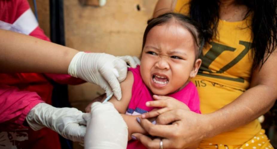 A child reacts during a Philippine Read Cross Measles Outbreak Vaccination Response in Manila on February 16, 2019.  By Noel CELIS (AFP/File)