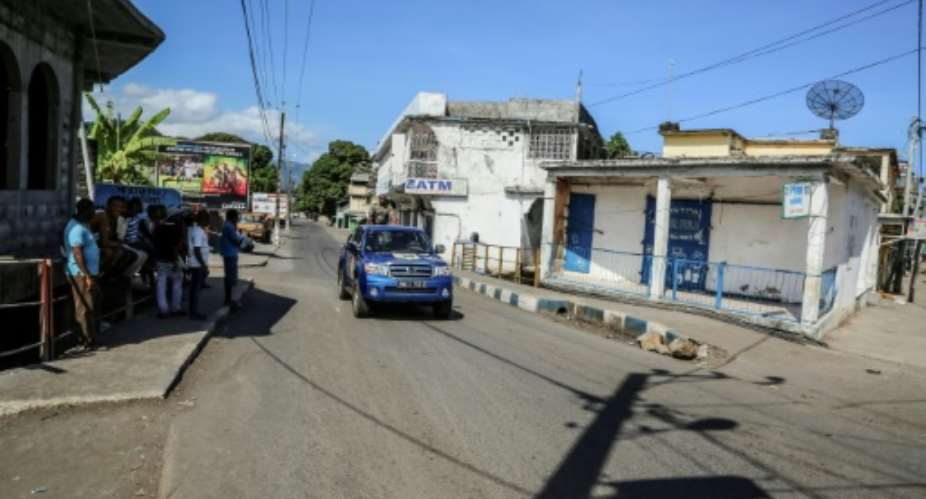 A Comoros police vehicle patrols the tense, deserted streets of Mutsamudu, where rebels oppose President Azali Assoumani's bids to extend term limits through constitutional changes.  By YOUSSOUF IBRAHIM AFP