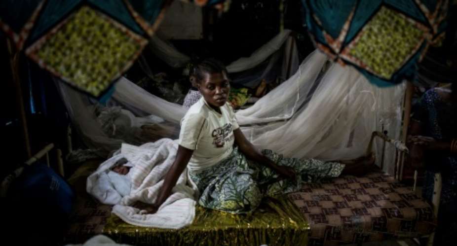 A Congolese woman rests with her newborn child at a clinic for displaced in Bunia. Tens of thousands of people have fled their homes since fighting between rival ethnic groups flared last December.  By JOHN WESSELS AFP