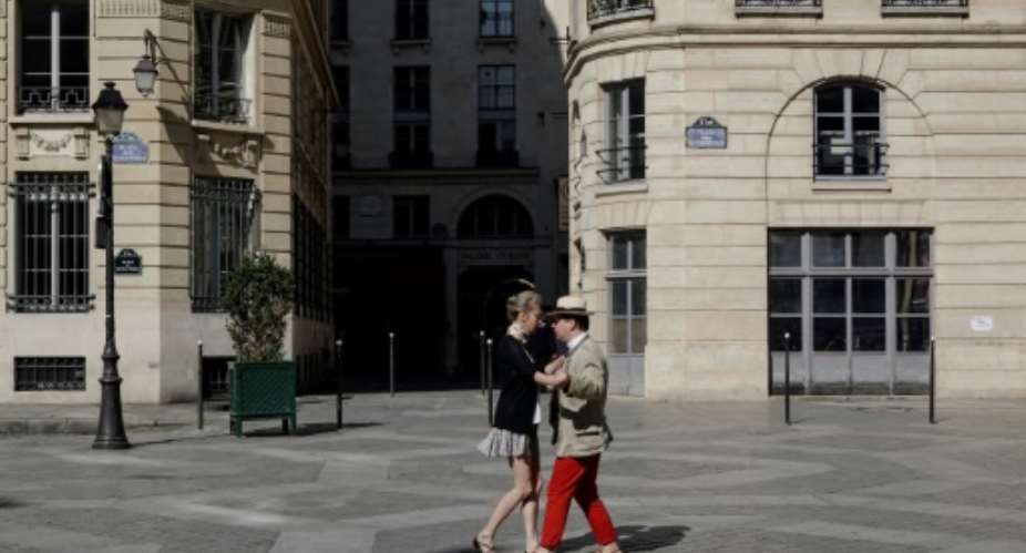 A couple dance in a empty square in downtown Paris on day 23 of a lockdown that is expected to be extended past the original deadline of April 15, 2020.  By Stefano RELLANDINI AFP