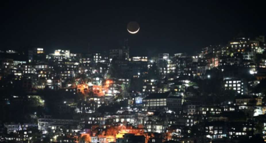 A crescent moon over homes on a hillside in Aizawl, capital of the northeastern Indian state of Mizoram.  By Sajjad HUSSAIN AFP